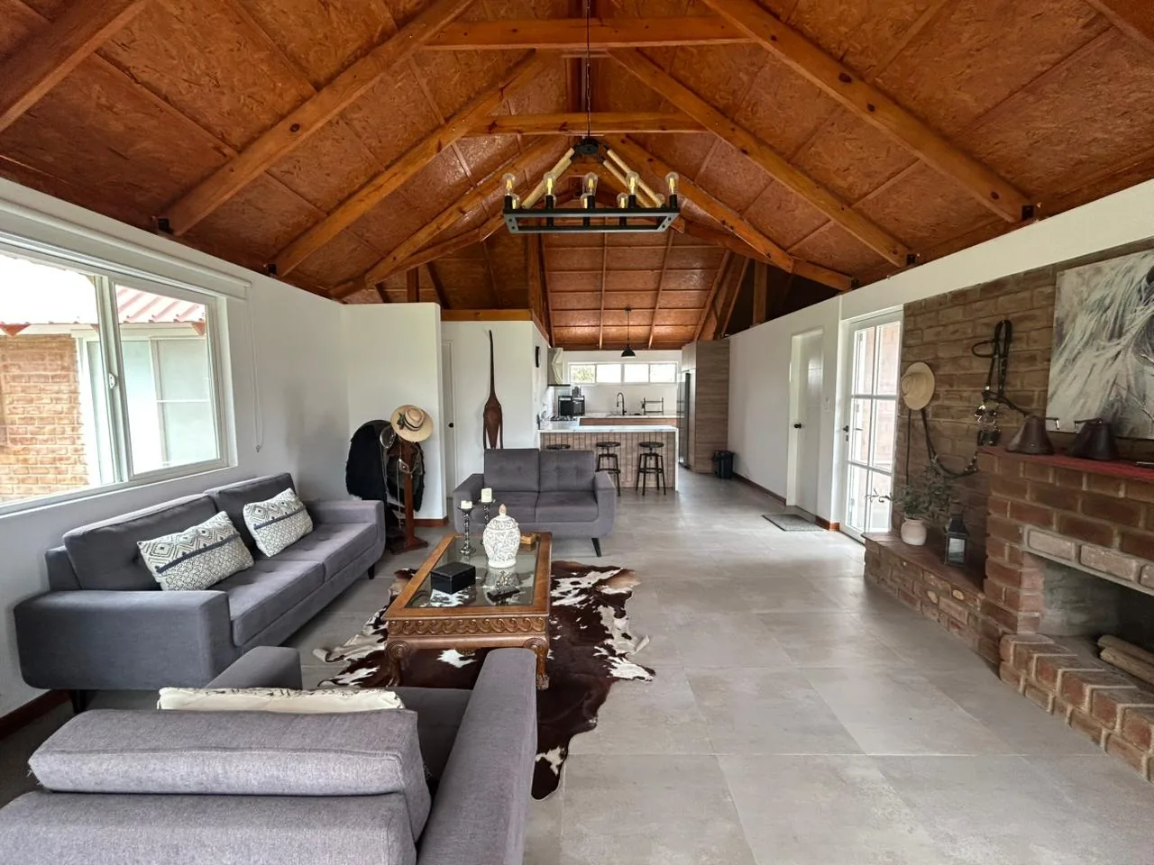 Sala de estar con techo de madera y chimenea — bungalow Cinco Olivos