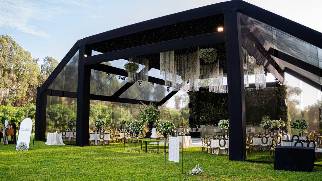 Interior del Jardín Cinco Olivos decorado con cortinas doradas y luces para evento de gala